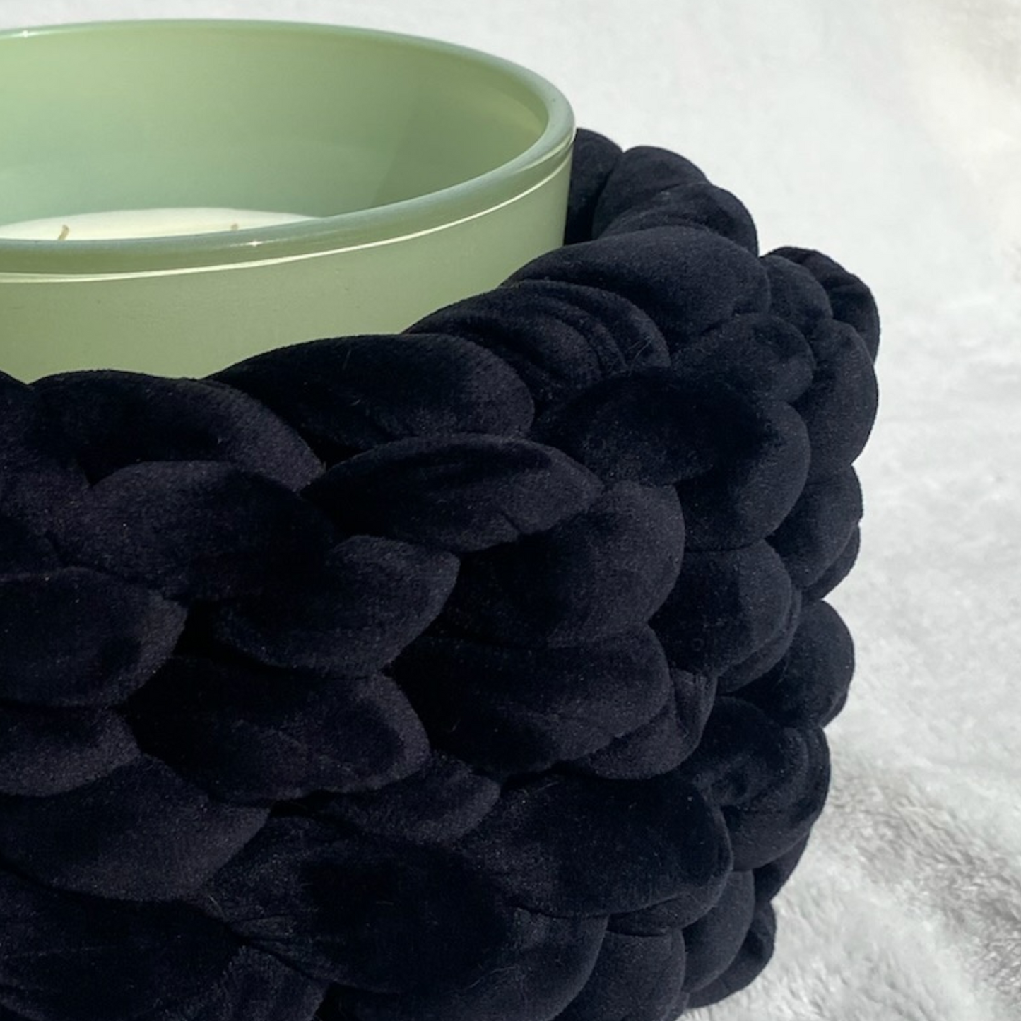 Duftkerze in einem grünem Glas mit einer Manschette aus Samt in der Farbe Schwarz